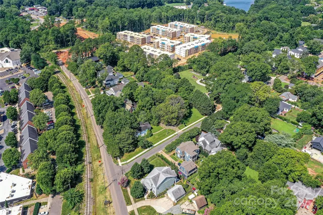 an aerial view of a residential houses with yard and green space