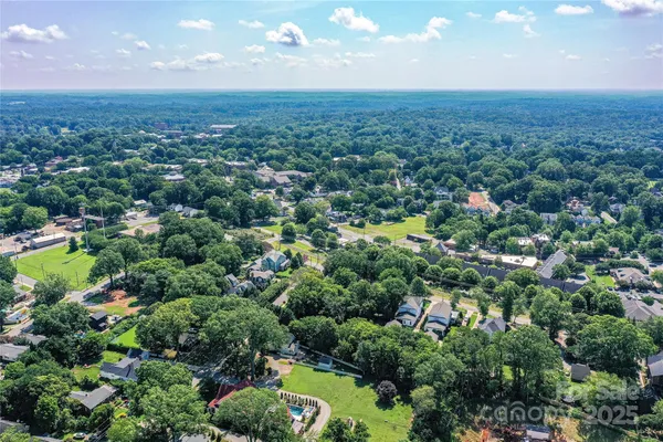 an aerial view of a houses with a yard and lake view