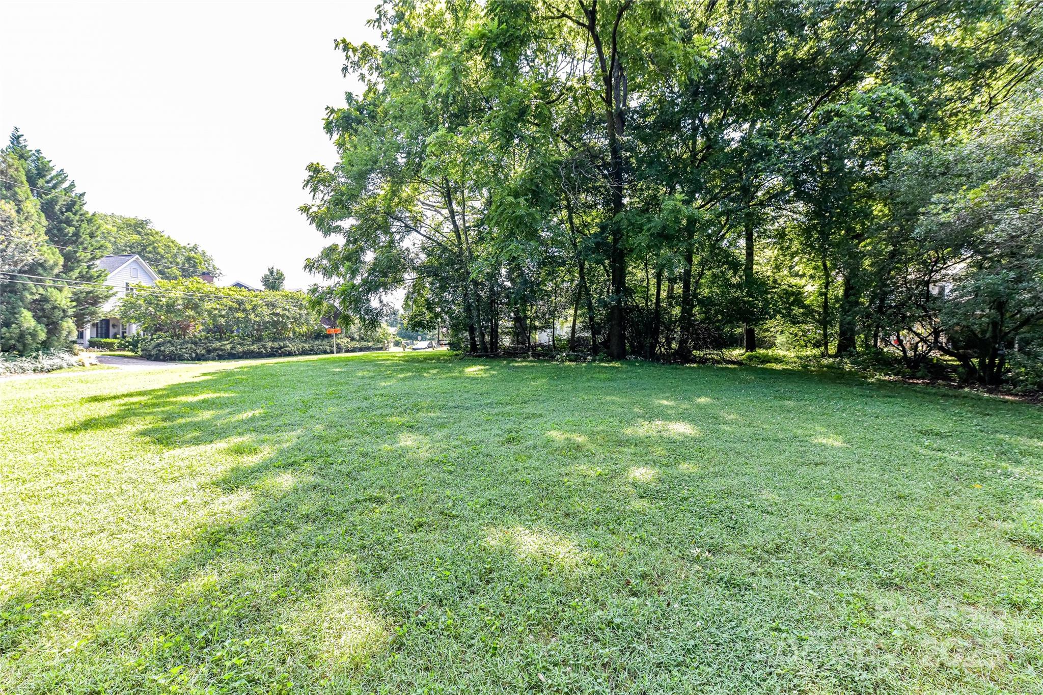 504 Potts Street Davidson, NC 28036 - Photo 8 of 34 a view of a grassy field with trees in the background