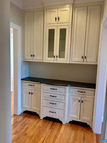 a kitchen with granite countertop white cabinets and sink