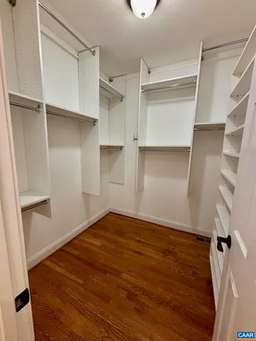 a view of walk in closet with empty racks