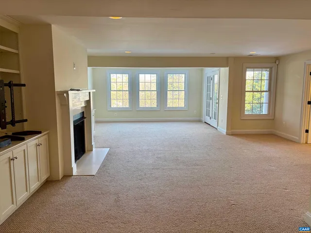 a big room with windows and a fireplace