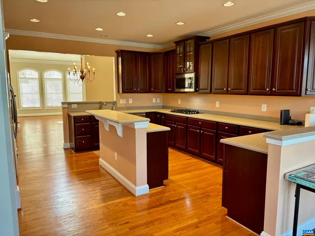 a kitchen with stainless steel appliances granite countertop wooden cabinets a stove top oven a sink and dishwasher
