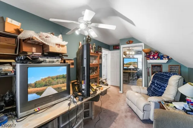 a living room with furniture a flat screen tv and floor to ceiling window