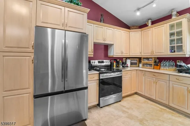a kitchen with stainless steel appliances granite countertop a refrigerator a stove a sink and a microwave