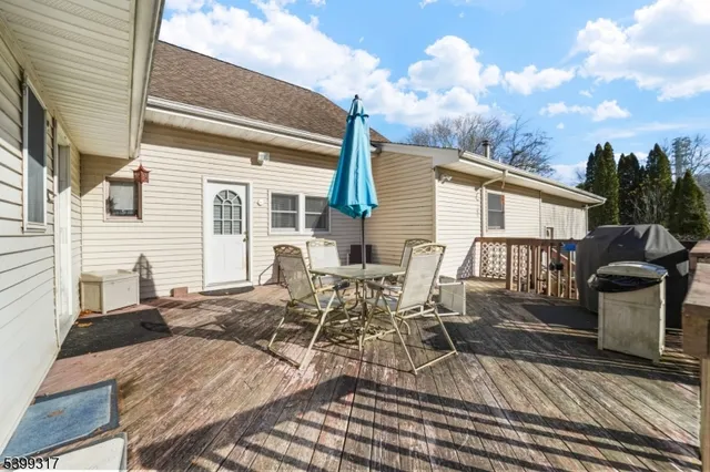 a view of a patio with table and chairs with wooden floor and fence