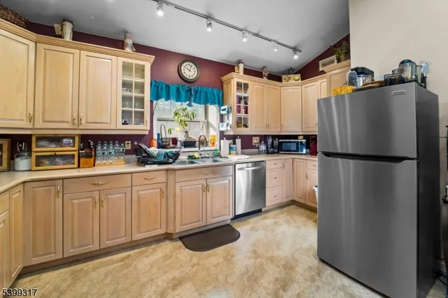 a kitchen with white cabinets and refrigerator