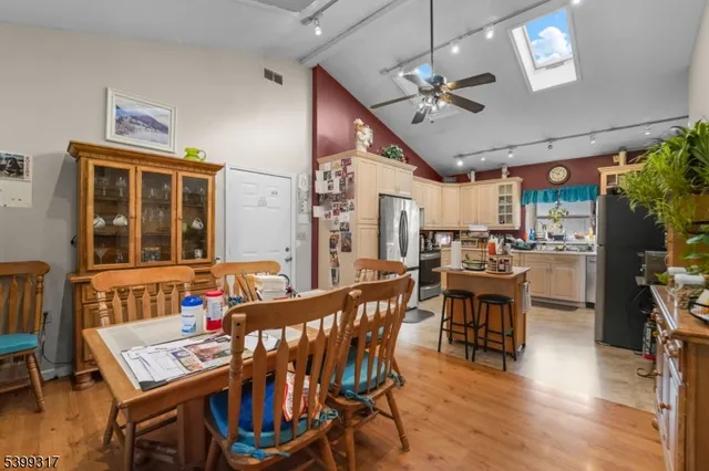 a dining room with wooden floor a chandelier a wooden table and chairs