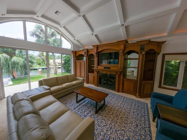 a living room with furniture a fireplace and a floor to ceiling window