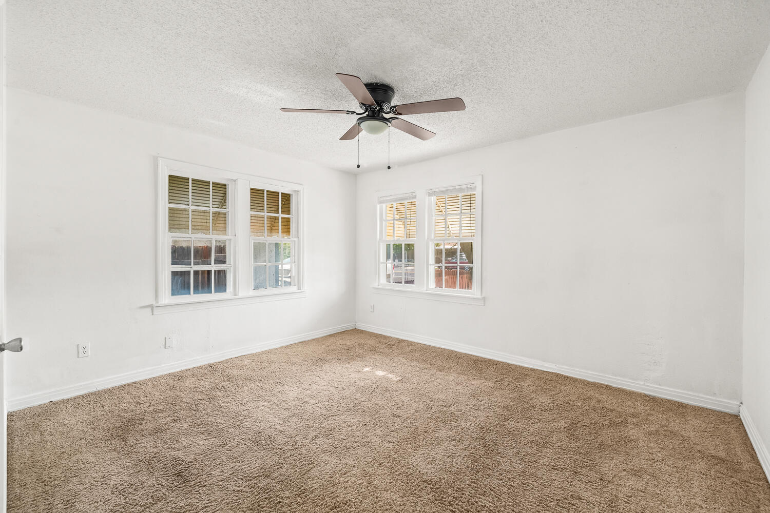111 Avenue U Lubbock, TX 79415 - Photo 8 of 17 an empty room with windows and fan