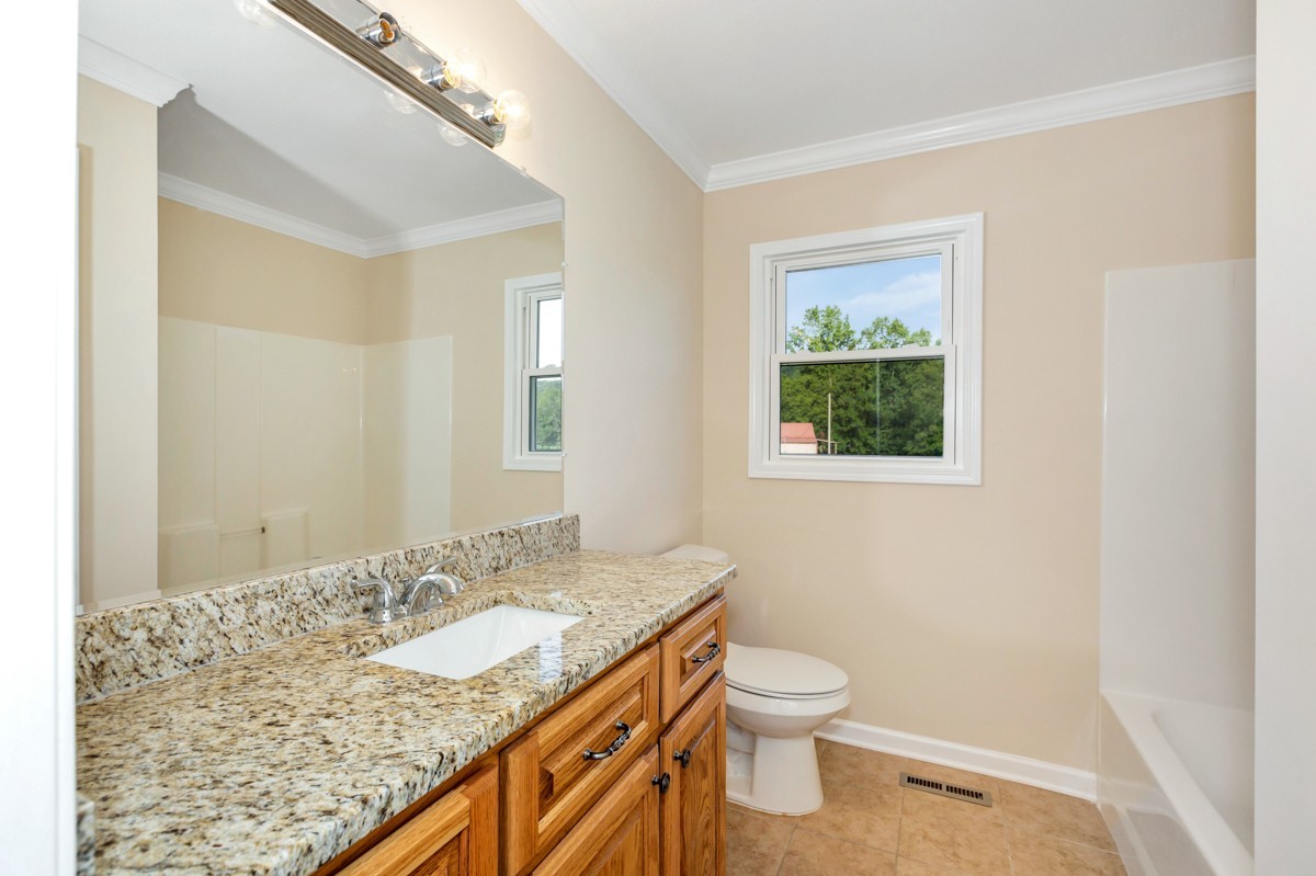 477 Holt Hollow Road Prospect, TN 38477 - Photo 15 of 34 a bathroom with a granite countertop sink a toilet and a shower