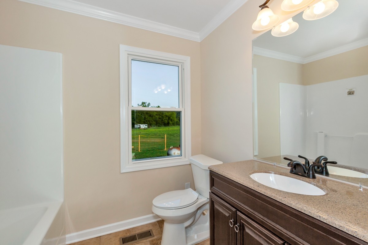 477 Holt Hollow Road Prospect, TN 38477 - Photo 19 of 34 a bathroom with a granite countertop toilet sink and mirror