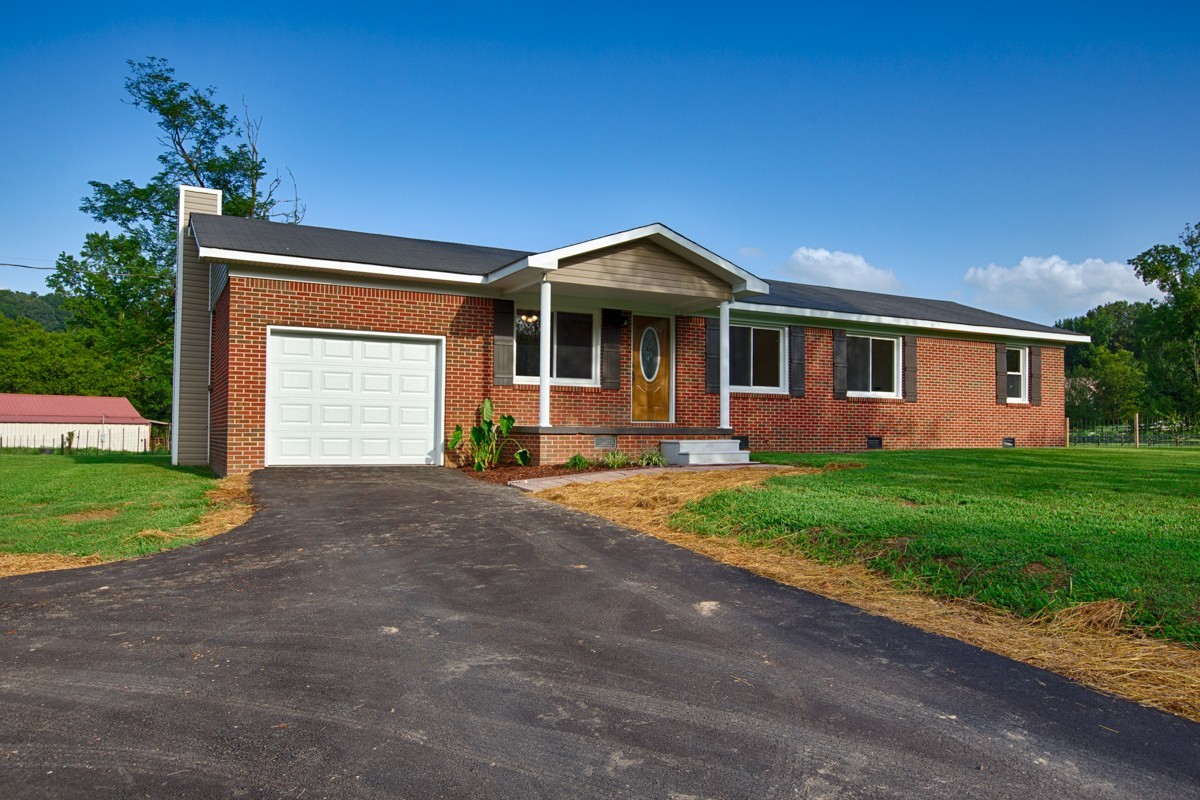 477 Holt Hollow Road Prospect, TN 38477 - Photo 3 of 34 a front view of a house with a yard and garage