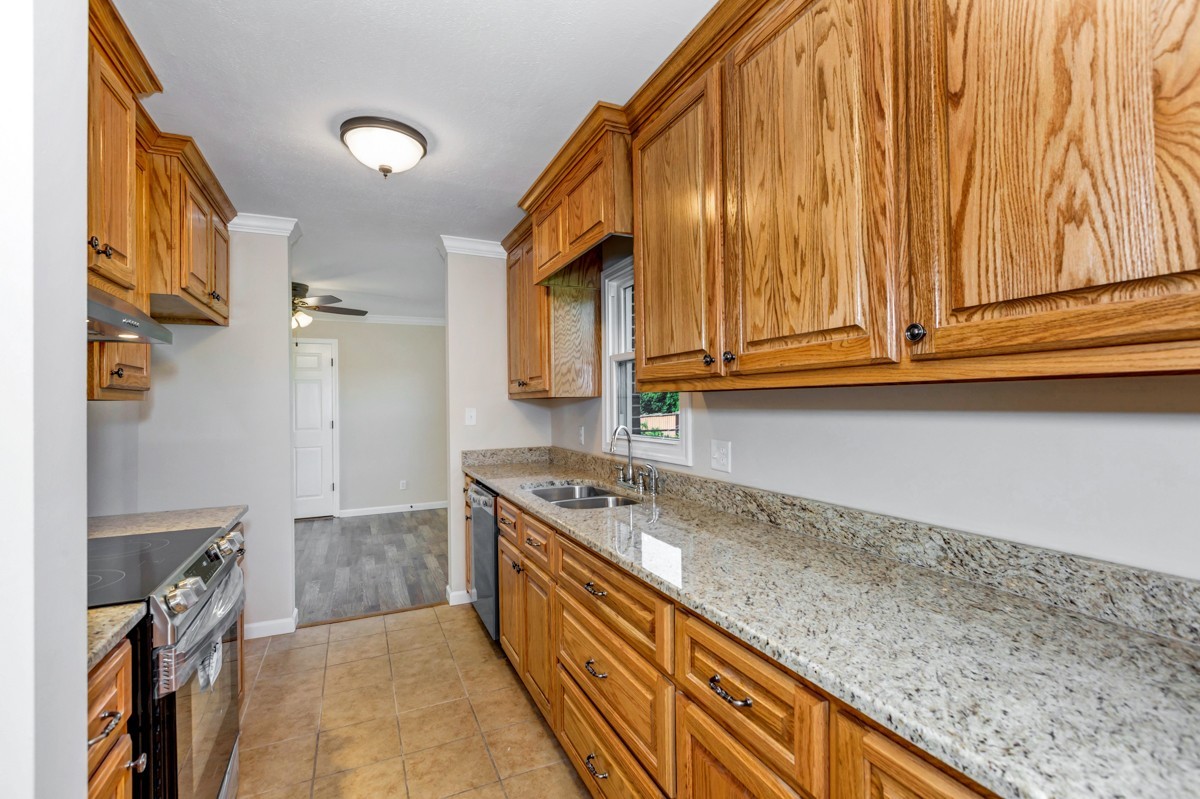 477 Holt Hollow Road Prospect, TN 38477 - Photo 9 of 34 a kitchen with granite countertop cabinets stainless steel appliances a sink and wooden floor