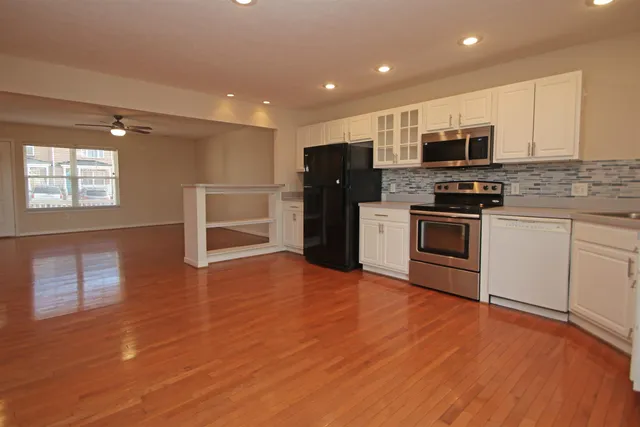 a large kitchen with stainless steel appliances granite countertop a stove and a refrigerator
