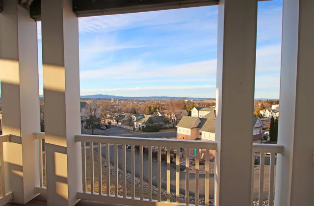 a view of a balcony with wooden floor & fence