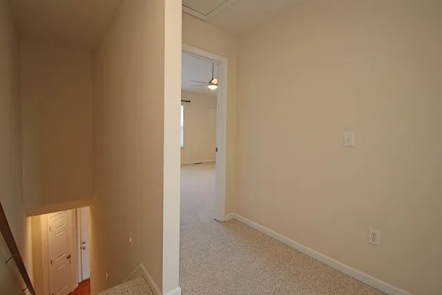 an empty room with a window and a fan