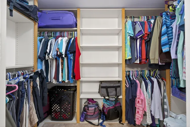 a view of walk in closet with clothes