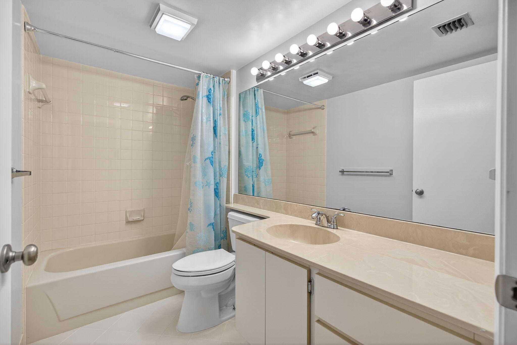 2441 Village Boulevard, Unit 405 West Palm Beach, FL 33409 - Photo 17 of 24 a bathroom with a granite countertop sink a toilet a mirror and shower