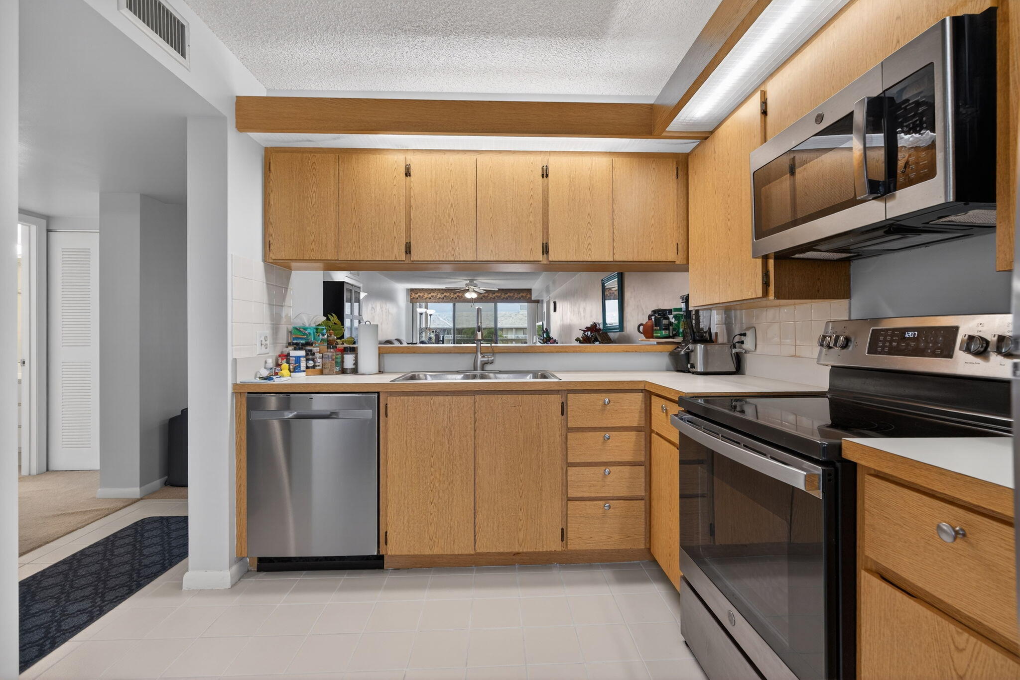 2441 Village Boulevard, Unit 405 West Palm Beach, FL 33409 - Photo 4 of 24 a kitchen with stainless steel appliances granite countertop a sink and a refrigerator