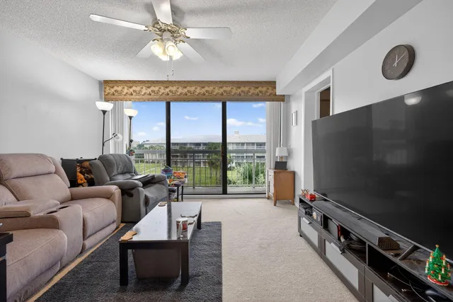 a living room with furniture a flat screen tv and a large window