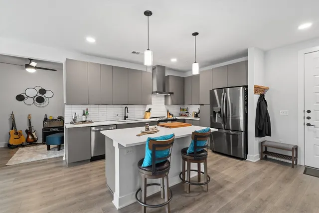 a kitchen with a refrigerator a stove and a wooden floor