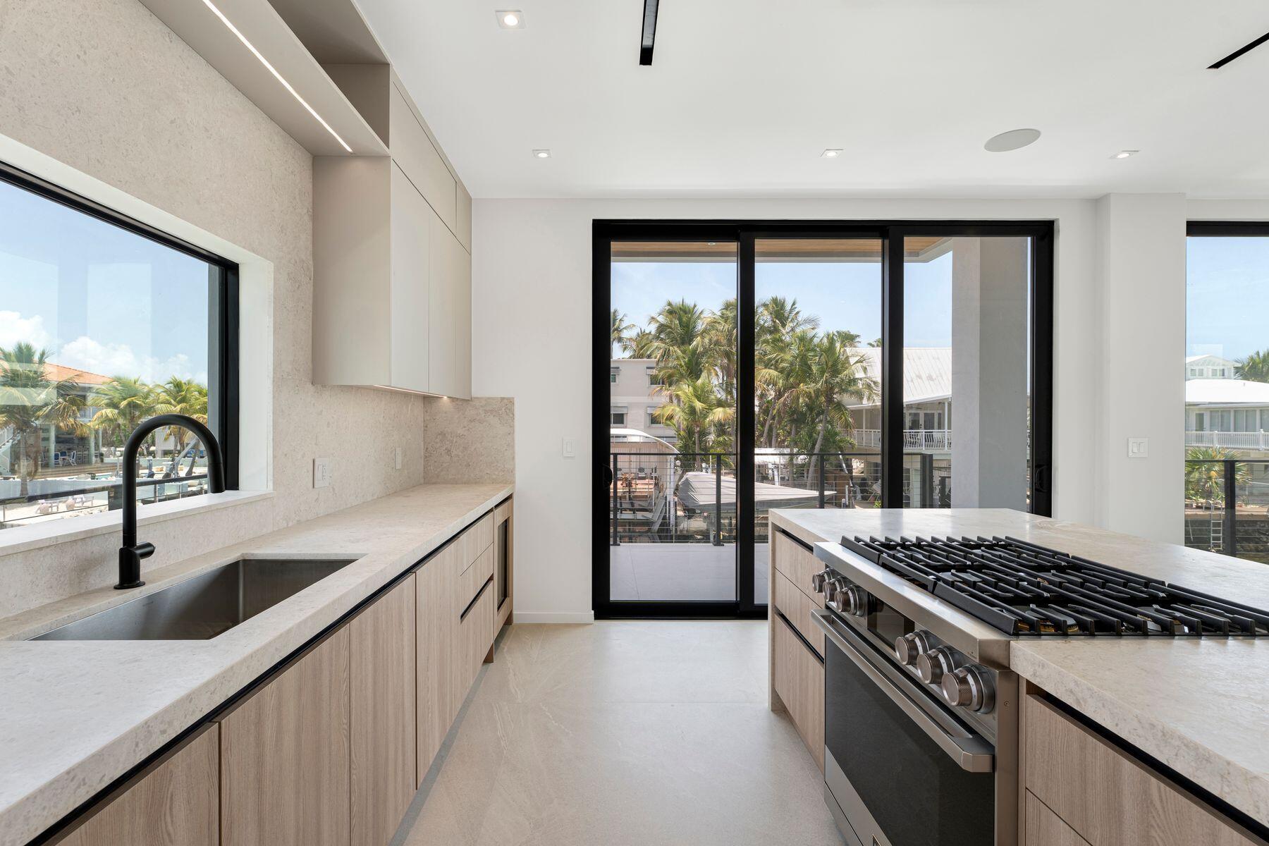 301 Buttonwood Circle, Unit B Key Largo, FL 33037 - Photo 14 of 40 a kitchen that has a sink stainless steel appliances a counter space and a window