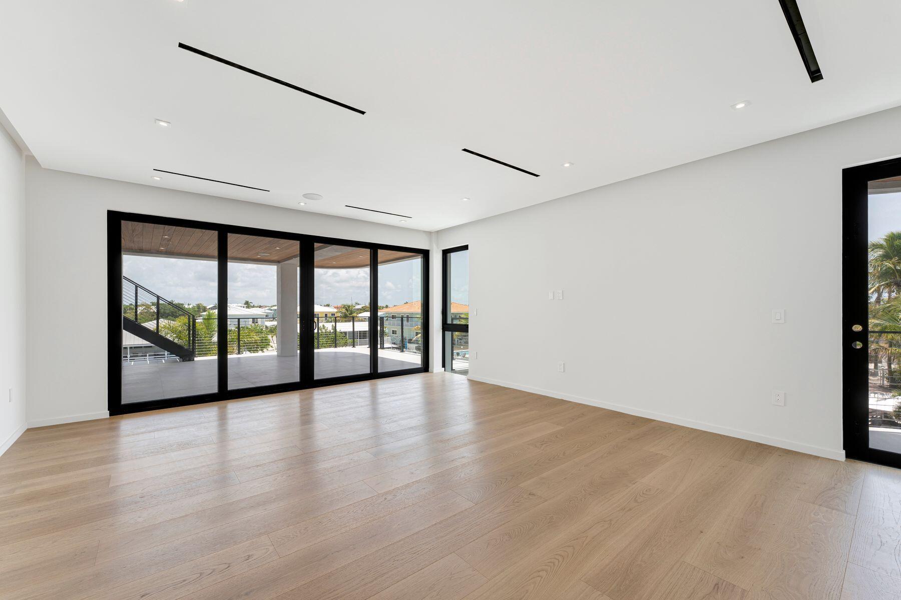 301 Buttonwood Circle, Unit B Key Largo, FL 33037 - Photo 19 of 40 a view of an empty room with wooden floor and a window