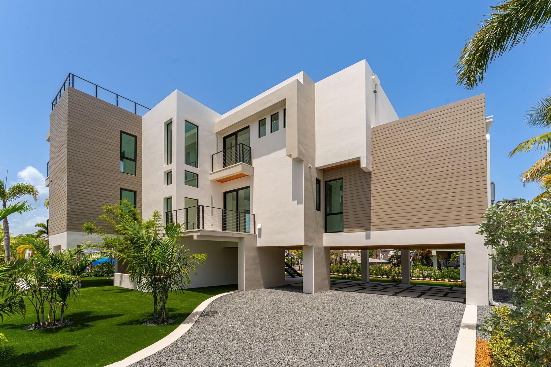 301 Buttonwood Circle, Unit B Key Largo, FL 33037 - Photo 2 of 40 a front view of a house with a garden and plants