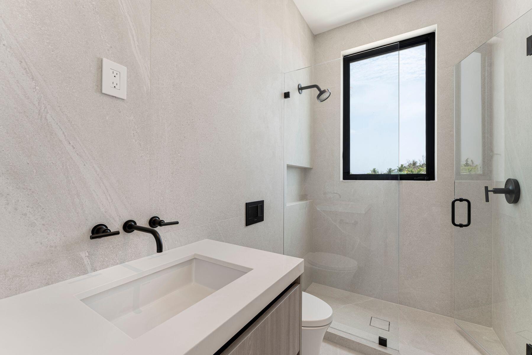 301 Buttonwood Circle, Unit B Key Largo, FL 33037 - Photo 28 of 40 a bathroom with a sink a toilet and shower