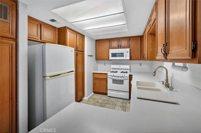 a kitchen with stainless steel appliances granite countertop a refrigerator sink stove and microwave