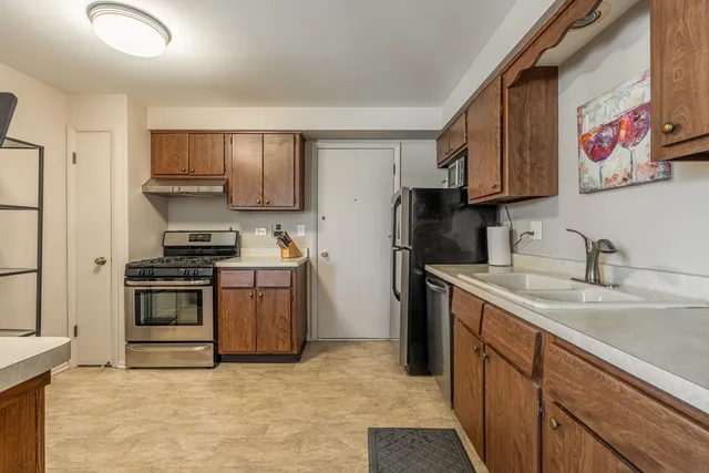 a kitchen with stainless steel appliances granite countertop a stove sink and refrigerator