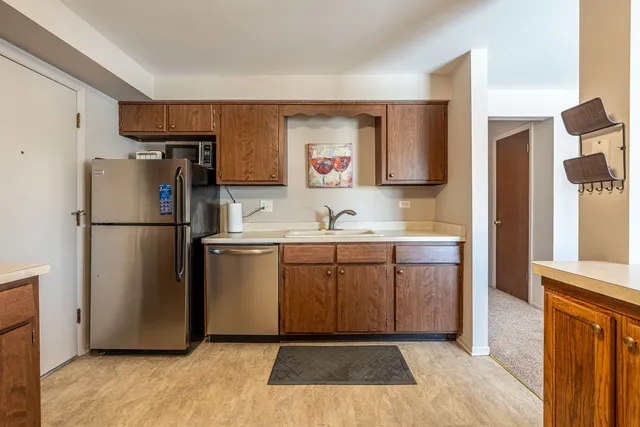 a kitchen with a refrigerator sink and cabinets