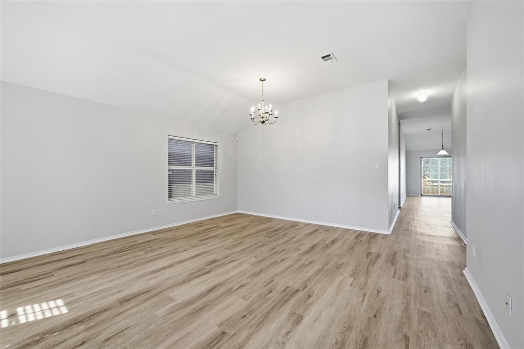 1703 Caladium Drive Corinth, TX 76210 - Photo 6 of 24 a view of an empty room with wooden floor and a window