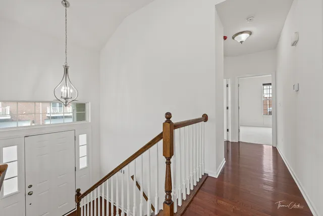 a view of a hallway with wooden floor and staircase