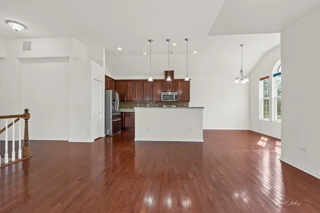 a view of open kitchen with wooden floor and electronic appliances