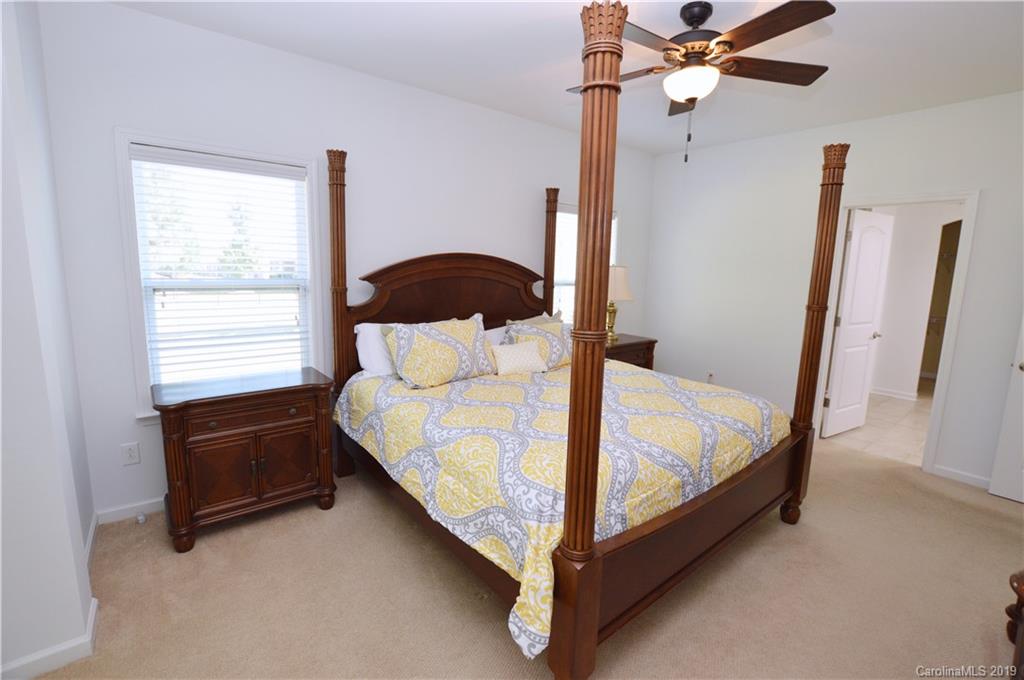 1898 Larkspur Way Tega Cay, SC 29708 - Photo 17 of 35 a bed sitting in a bedroom next to a window