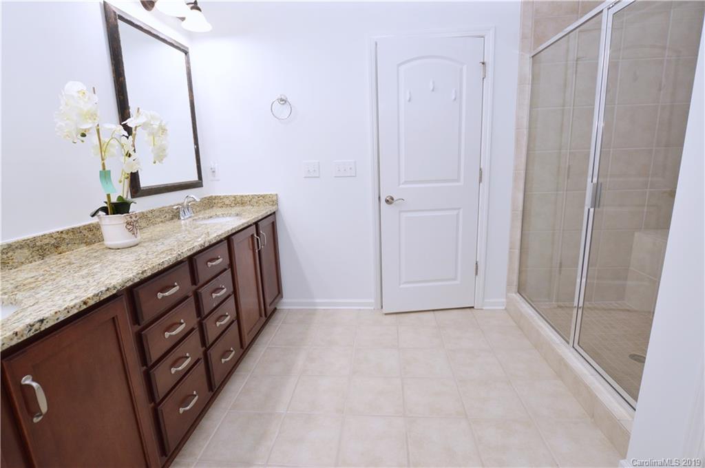 1898 Larkspur Way Tega Cay, SC 29708 - Photo 21 of 35 a bathroom with a granite countertop sink a mirror and shower