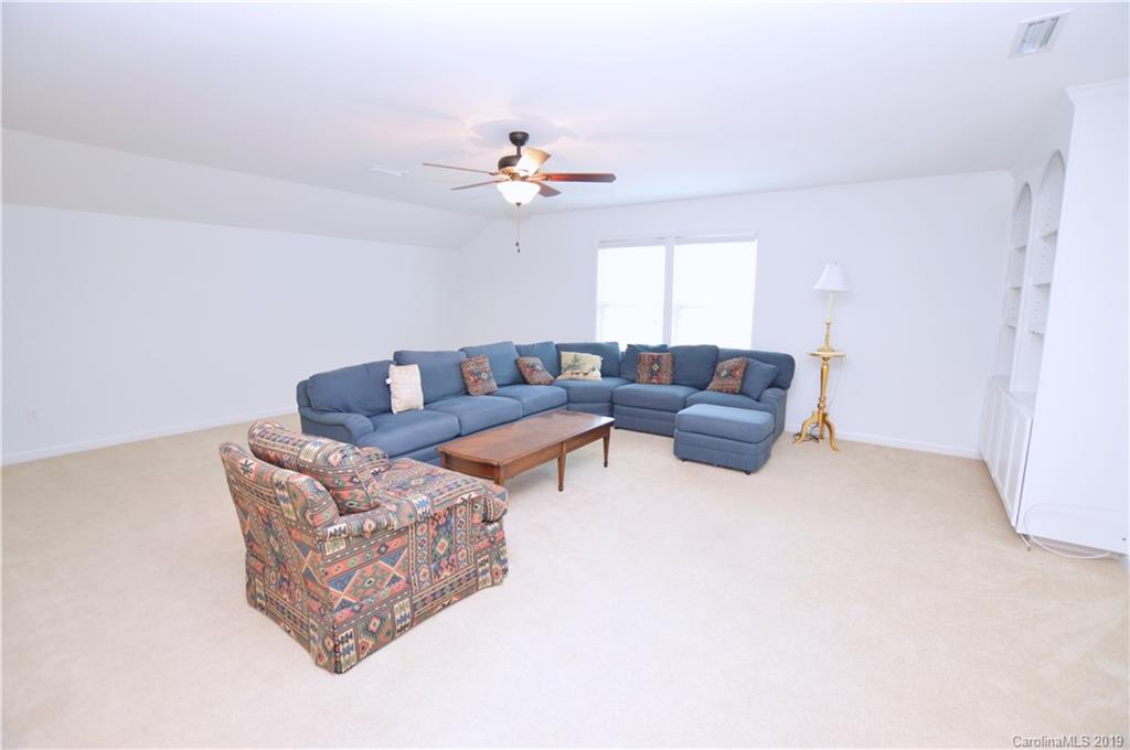 1898 Larkspur Way Tega Cay, SC 29708 - Photo 22 of 35 a living room with furniture and a chandelier