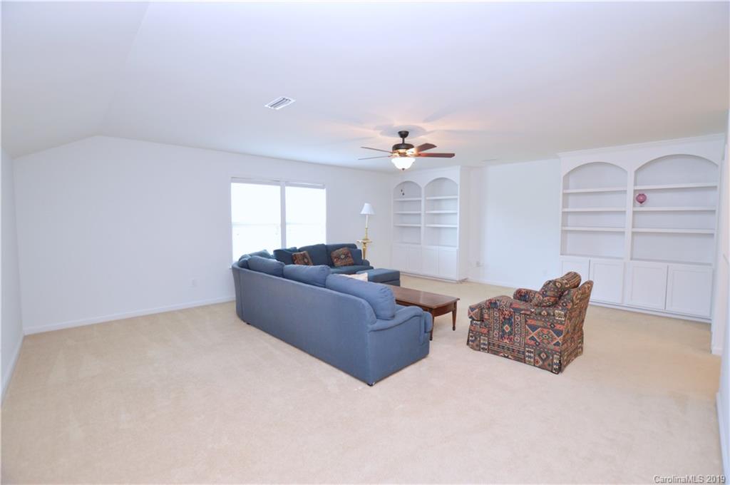 1898 Larkspur Way Tega Cay, SC 29708 - Photo 23 of 35 a living room with furniture and a chandelier