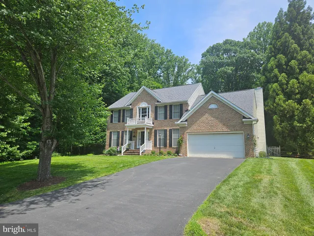 a front view of a house with a yard and trees