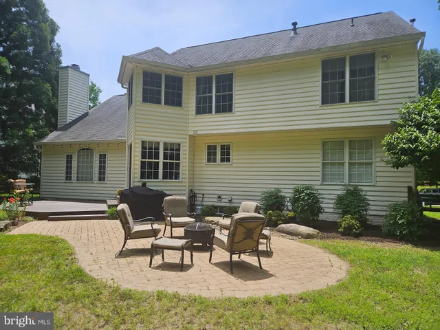 a view of a house with a patio and a yard