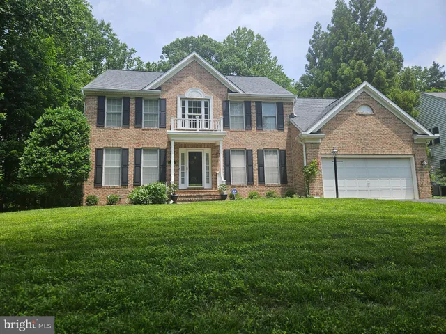 a front view of a house with a yard and trees