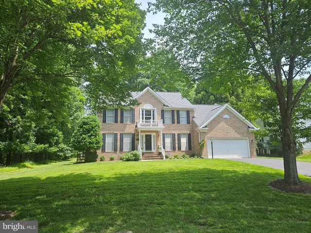 a front view of a house with a garden and trees