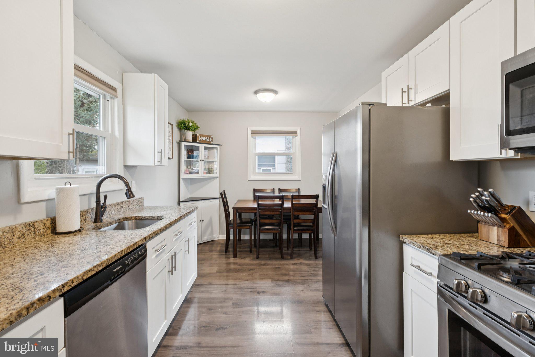 614 Brooke Avenue Magnolia, NJ 08049 - Photo 14 of 33 a kitchen with refrigerator and chairs