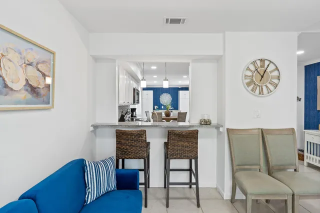 a dining room with a table chairs and a kitchen view