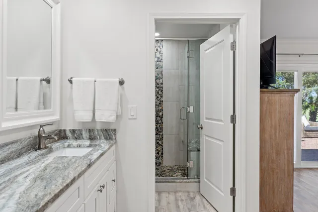 a bathroom with a granite countertop sink and a mirror
