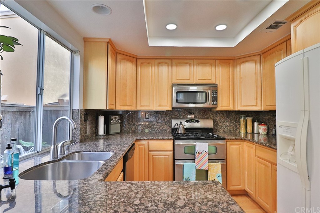 6 Rue Monet Lake Forest, CA 92610 - Photo 3 of 24 The kitchen showing the granite counter tops, stainless steel sink, range and microwave as well as the upgraded canned lighting.