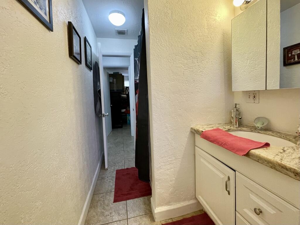 664 Colson Drive Key Largo, FL 33037 - Photo 20 of 36 a bathroom with a granite countertop sink and a refrigerator