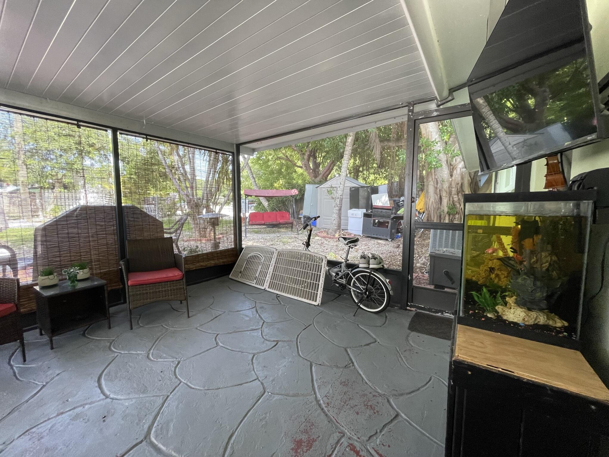 664 Colson Drive Key Largo, FL 33037 - Photo 29 of 36 a living room with furniture a flat screen tv and a floor to ceiling window